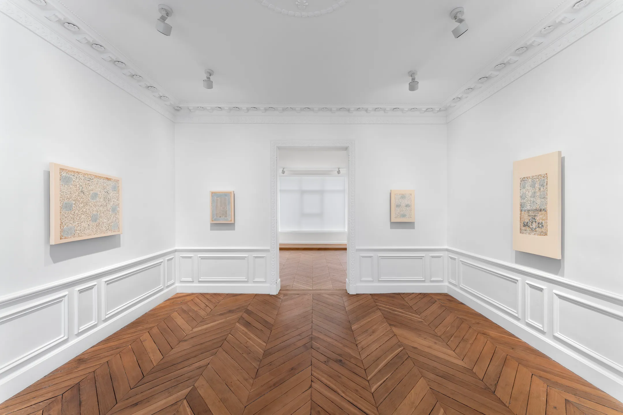 Paintings installed in a quiet gallery room
